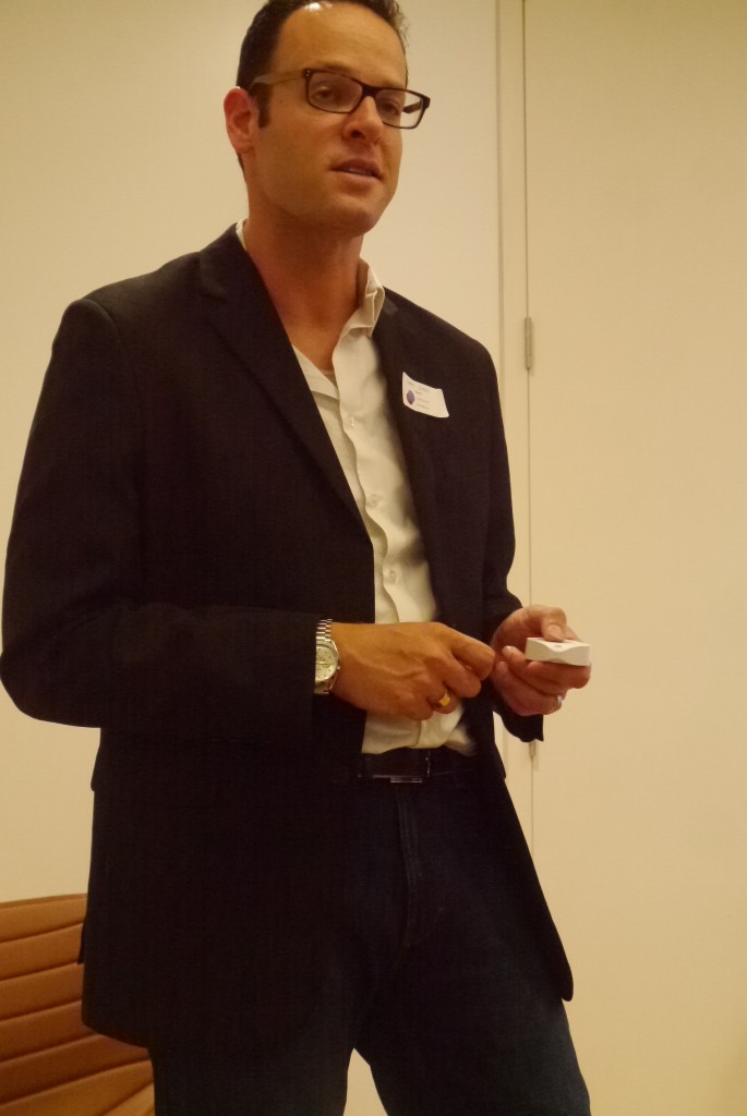 A picture of Kwik CEO Ofer Klein holding a white button device in his hands.